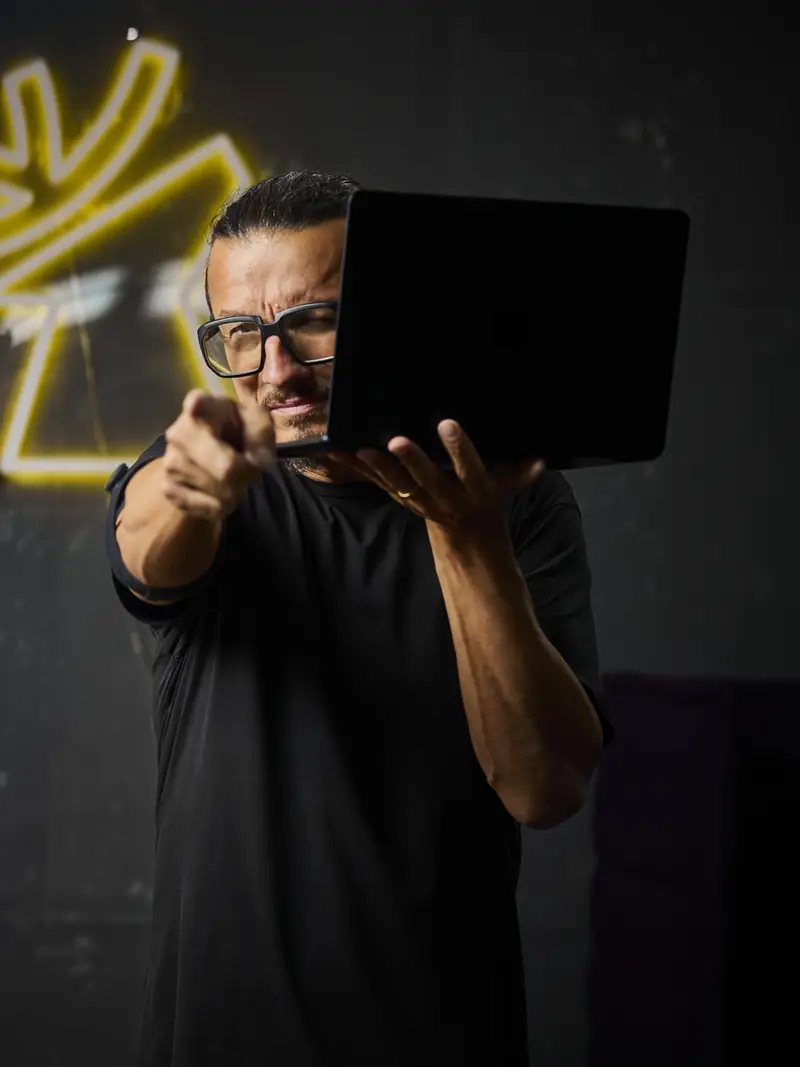 Markus Hirschmeier, Geschäftsführer von Hirschmeier Media, mit Laptop im Studio in Bielefeld